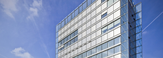 Gläsernes Bürogebäude vor klarem Himmel